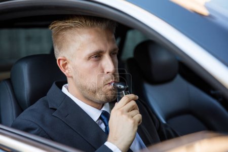 Photo for Man Sitting Inside Car Taking Alcohol Test - Royalty Free Image