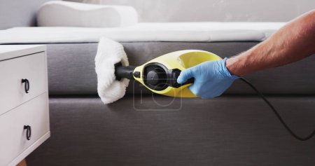 Téléchargez les photos : Nettoyage de lutte antiparasitaire de punaise de lit utilisant la machine à vapeur - en image libre de droit