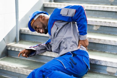 Foto de Hombre trabajador acostado en la escalera después de un accidente de resbalón y caída - Imagen libre de derechos