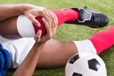 Téléchargez les photos : Gros plan d'un joueur de soccer masculin blessé sur le terrain - en image libre de droit