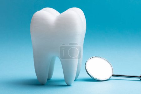 Foto de Primer plano del diente con espejo dental sobre fondo azul - Imagen libre de derechos