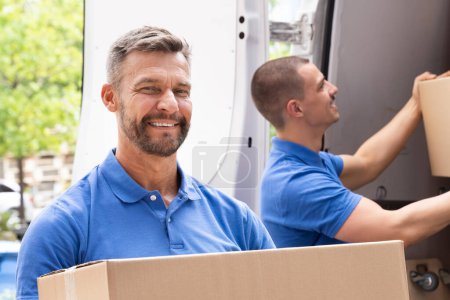 Truck Movers Loading Van Carrying Boxes And Moving House