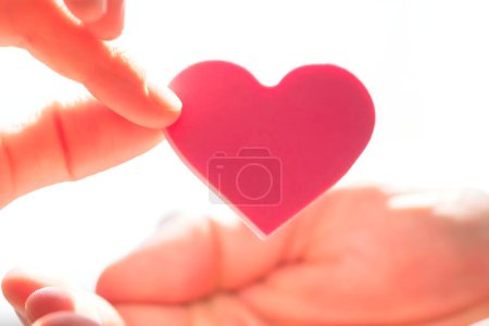 Téléchargez les photos : Gros plan de la femme donnant coeur rouge sur la main de l'homme - en image libre de droit