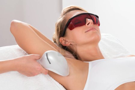Photo for Young woman having underarm laser hair removal treatment in salon - Royalty Free Image