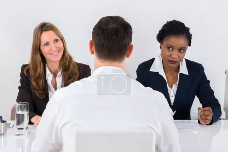 Photo for Group Of Businesspeople Interviewing Man In Office - Royalty Free Image