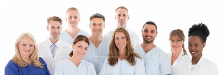 Foto de Retrato del feliz equipo médico multiétnico de pie sobre fondo blanco - Imagen libre de derechos