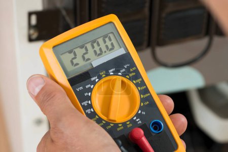 Photo for Cropped image of male repairman checking fridge with digital multimeter at home - Royalty Free Image
