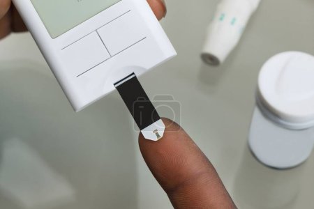 Téléchargez les photos : Gros plan des mains du patient mesurant le taux de glucose Test sanguin avec glucomètre - en image libre de droit