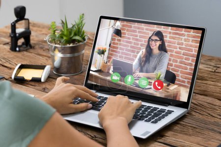 Téléchargez les photos : Jeune femme vidéoconférence avec un collègue sur l'ordinateur au bureau - en image libre de droit