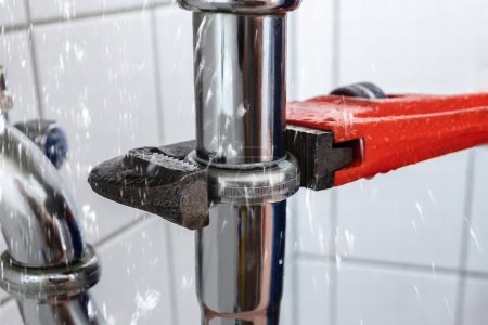 Téléchargez les photos : La fuite de tuyau d'évier de réparation de main de plombier masculin avec la clé réglable - en image libre de droit