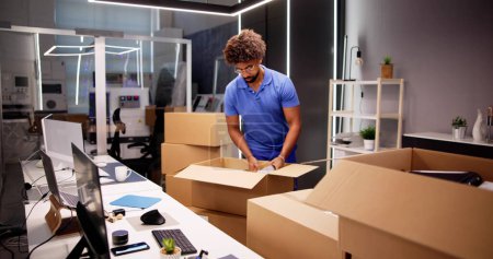 Photo for Professional Movers Packing Boxes In Modern Office - Royalty Free Image
