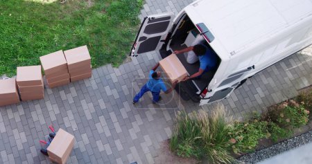 Téléchargez les photos : Vue à angle élevé des hommes de livraison déchargeant les boîtes en carton du camion - en image libre de droit
