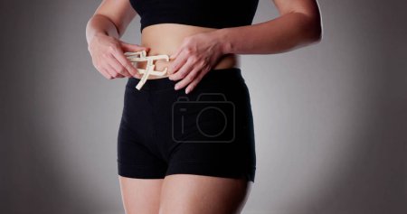 Photo for Close-up Of A Athlete Person Measuring Her Body Fat With Caliper In The Gym - Royalty Free Image