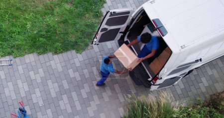 Foto de Vista de ángulo alto de los hombres de entrega que descargan las cajas de cartón del camión - Imagen libre de derechos
