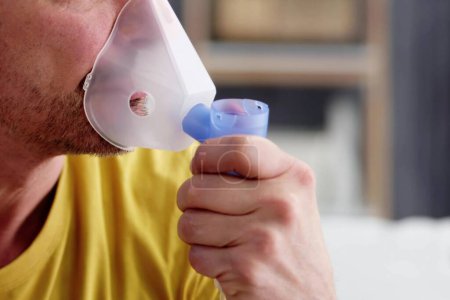 Foto de Paciente con EPOC y asma usando máscara nebulizadora para tratamiento de fibrosis quística - Imagen libre de derechos