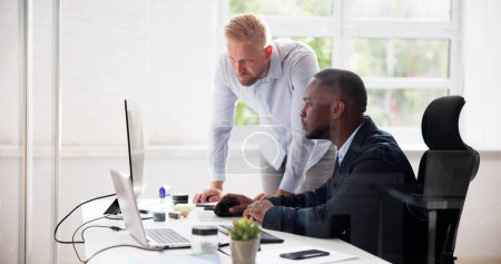 Téléchargez les photos : Homme d'affaires afro-américain employé travaillant au bureau avec un collègue - en image libre de droit