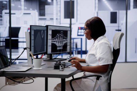 Téléchargez les photos : Ingénieur faisant la conception de modèle de CAO 3D sur l'ordinateur à l'usine - en image libre de droit