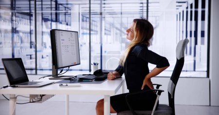 Foto de Dolor de espalda Mala postura Mujer sentada en la oficina - Imagen libre de derechos