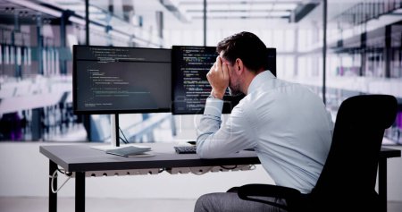 Foto de Unhappy Sad Developer Programmer Man In Stress Coding Software On Computer - Imagen libre de derechos