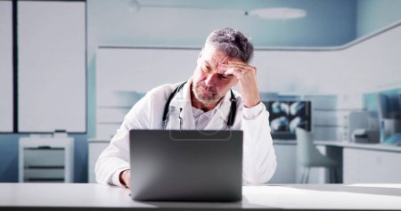 Photo for Sad Man Doctor Stress And Pain At Computer - Royalty Free Image