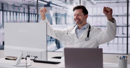 Photo for Happy Excited Male Doctor Raising Arms In Hospital - Royalty Free Image