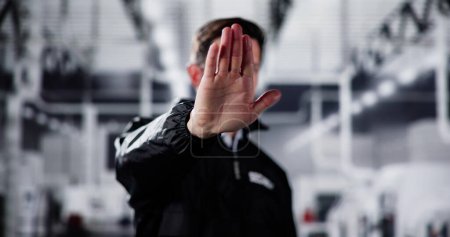 Téléchargez les photos : Agent de sécurité de garde faisant geste d'arrêt dans l'usine de puces - en image libre de droit