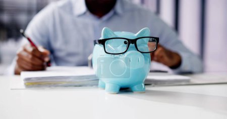 Téléchargez les photos : Conseiller financier avec Piggybank. Calcul de l'épargne-argent - en image libre de droit