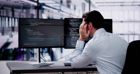 Foto de Unhappy Sad Developer Programmer Man In Stress Coding Software On Computer - Imagen libre de derechos