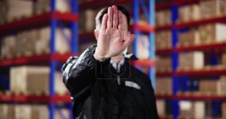 Photo for Guard Security Making Stop Gesture In Logistic Business Distribution Warehouse - Royalty Free Image