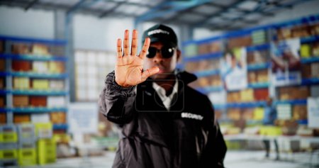 Photo for Security Guard In Logistic Business Distribution Warehouse Making Stop Gesture - Royalty Free Image