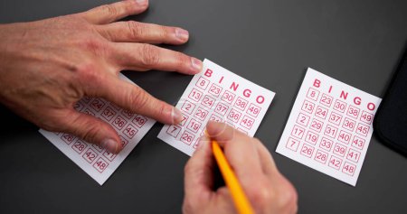 Foto de Número de marca de mano de la persona en billete de lotería con pluma - Imagen libre de derechos