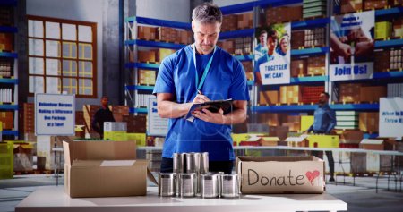 Téléchargez les photos : Banque alimentaire Aide humanitaire dans des boîtes de dons. Vérification volontaire de la nourriture - en image libre de droit