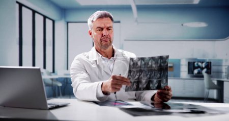 Foto de Médico de detección de espina dorsal huesos rayos X en la oficina - Imagen libre de derechos