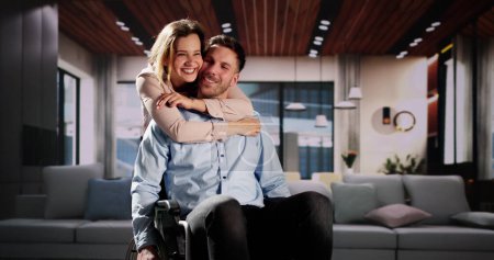 Téléchargez les photos : Couple heureux dans le salon. Homme en fauteuil roulant - en image libre de droit