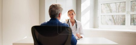 Photo for Medical Doctor And Patient In Hospital. Man Talking To Physician - Royalty Free Image