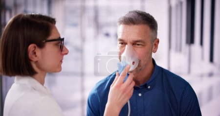 Téléchargez les photos : Masque à oxygène pour les maladies pulmonaires et la fibrose. Homme inhalant - en image libre de droit