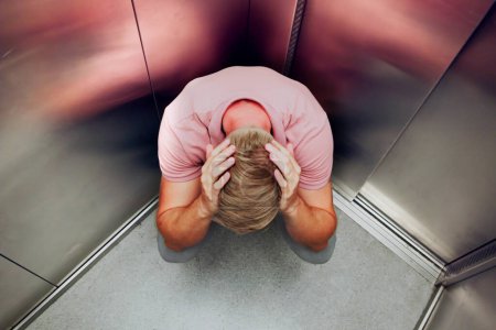 Foto de Hombre atrapado dentro del ascensor: superando la claustrofobia y el miedo - Imagen libre de derechos