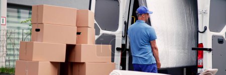 Téléchargez les photos : Les déménageurs professionnels livrent le matelas et les meubles avec le camion - en image libre de droit