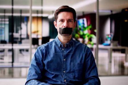 Foto de Joven con cinta adhesiva negra sobre su boca en la oficina - Imagen libre de derechos