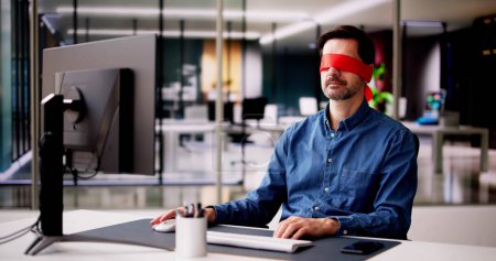 Téléchargez les photos : Confus Blindfolded Man Concept. Travailleur de bureau utilisant un ordinateur - en image libre de droit