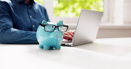 Photo for Save Money Online Using Bank Piggy And Laptop Computer - Royalty Free Image