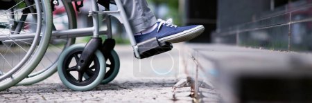 Foto de Hombre en silla de ruedas accediendo a escaleras con asistencia - Imagen libre de derechos