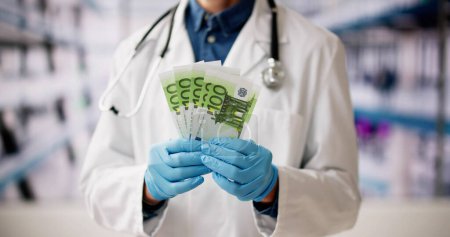Foto de Doctor Rico sosteniendo el dinero. Buen dinero en efectivo en la clínica - Imagen libre de derechos