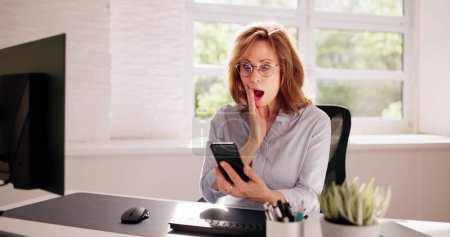 Téléchargez les photos : Femme inquiète regardant Smartphone et assis dans le bureau - en image libre de droit