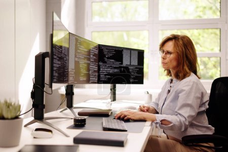 Téléchargez les photos : Programmeur de logiciel ou femme de codeur utilisant l'ordinateur de bureau - en image libre de droit