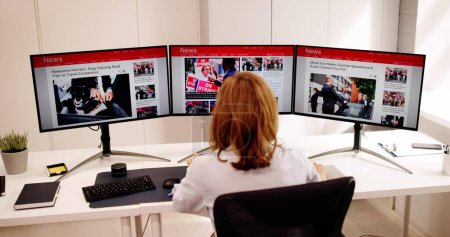Foto de Mujer mirando las noticias en el periódico en línea en la computadora - Imagen libre de derechos