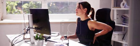 Woman sitting in bad office posture causing back pain.