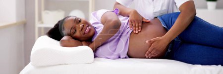 Téléchargez les photos : Femme noire recevant des soins doula pendant la physiothérapie de grossesse - en image libre de droit