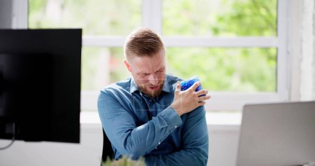 Foto de Primer plano de un hombre que aplica un paquete de gel fresco en su hombro - Imagen libre de derechos