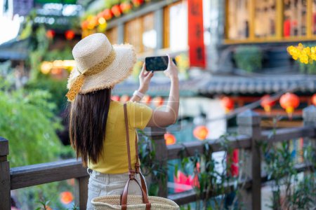 Téléchargez les photos : Femme touristique prendre des photos sur cellephone dans le village de Jiufen à Taiwan - en image libre de droit